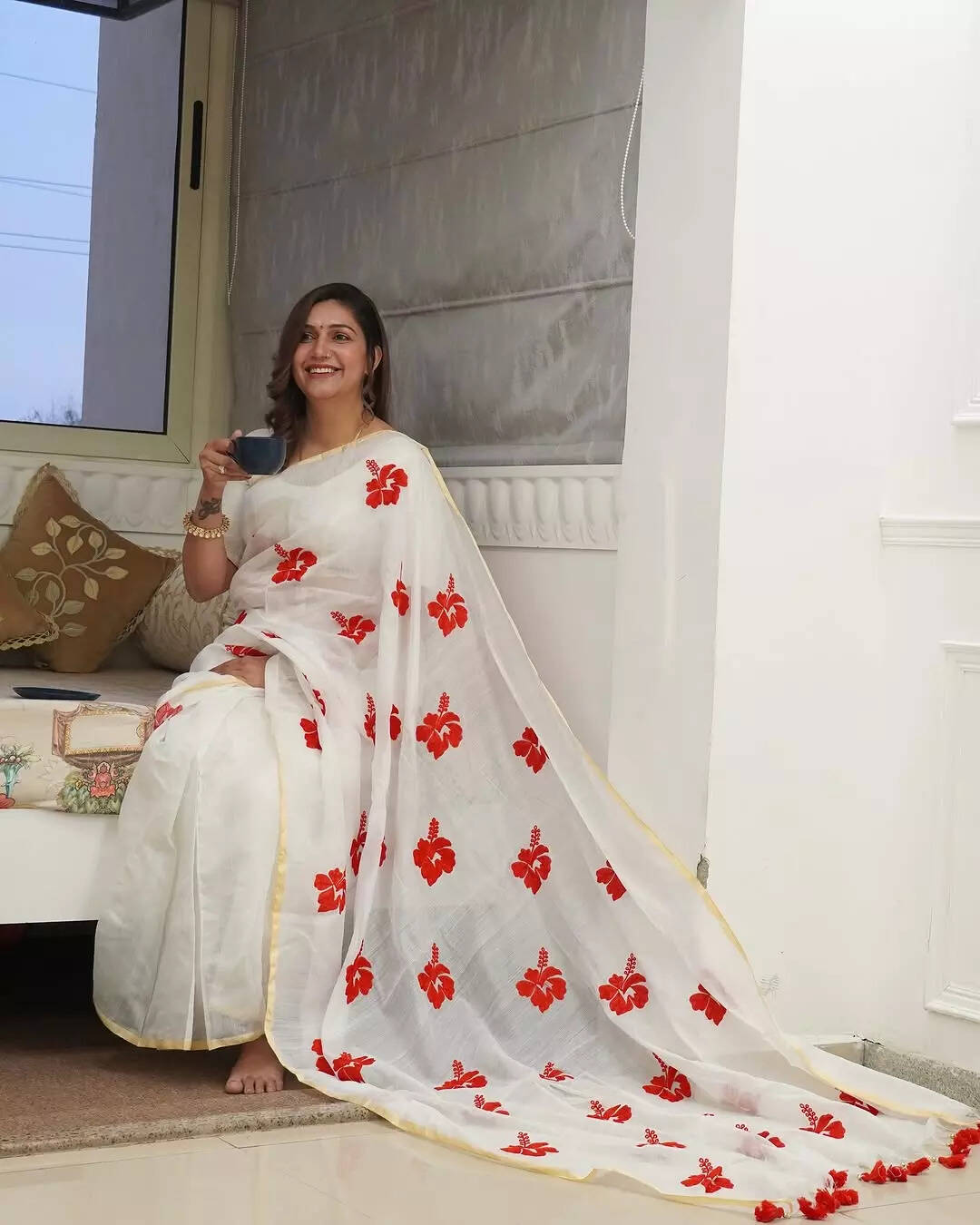 सफेद साड़ी पर चमक रहे हैं लाल फूल