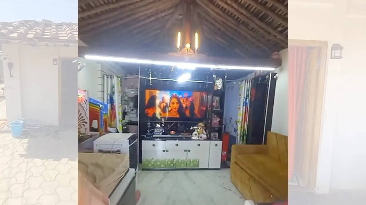 इतना ही झोपड़ी में बड़ी सी स्क्रीन लगी है और सामने सोफा रखा हुआ है।