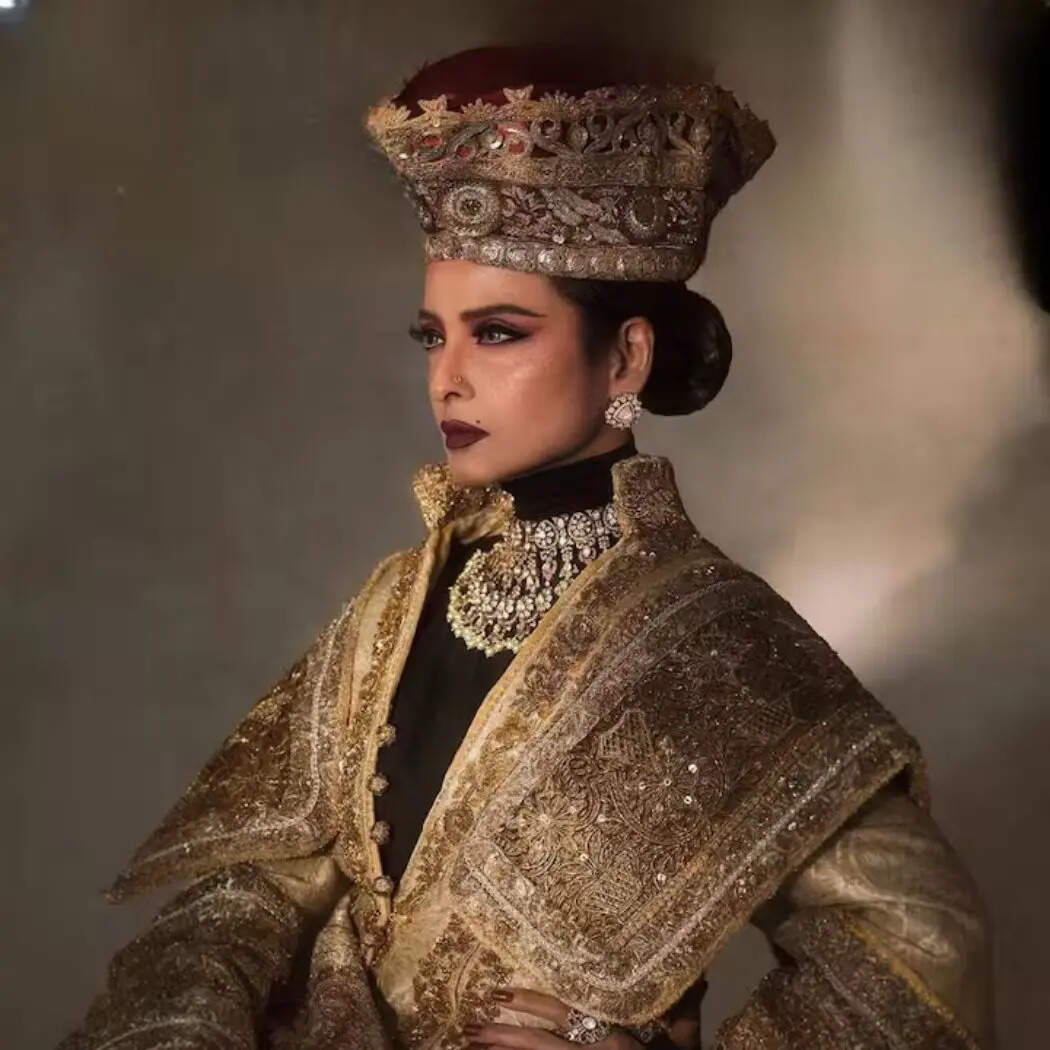 रेखा ने गोल्डन और भारी कढ़ाई वाले आउटफिट के साथ जड़ाऊ गहने पहने हैं। सिर पर बड़ा हेडगियर उन्हें महारानी जैसा लुक दे रहा है। Image Instagram