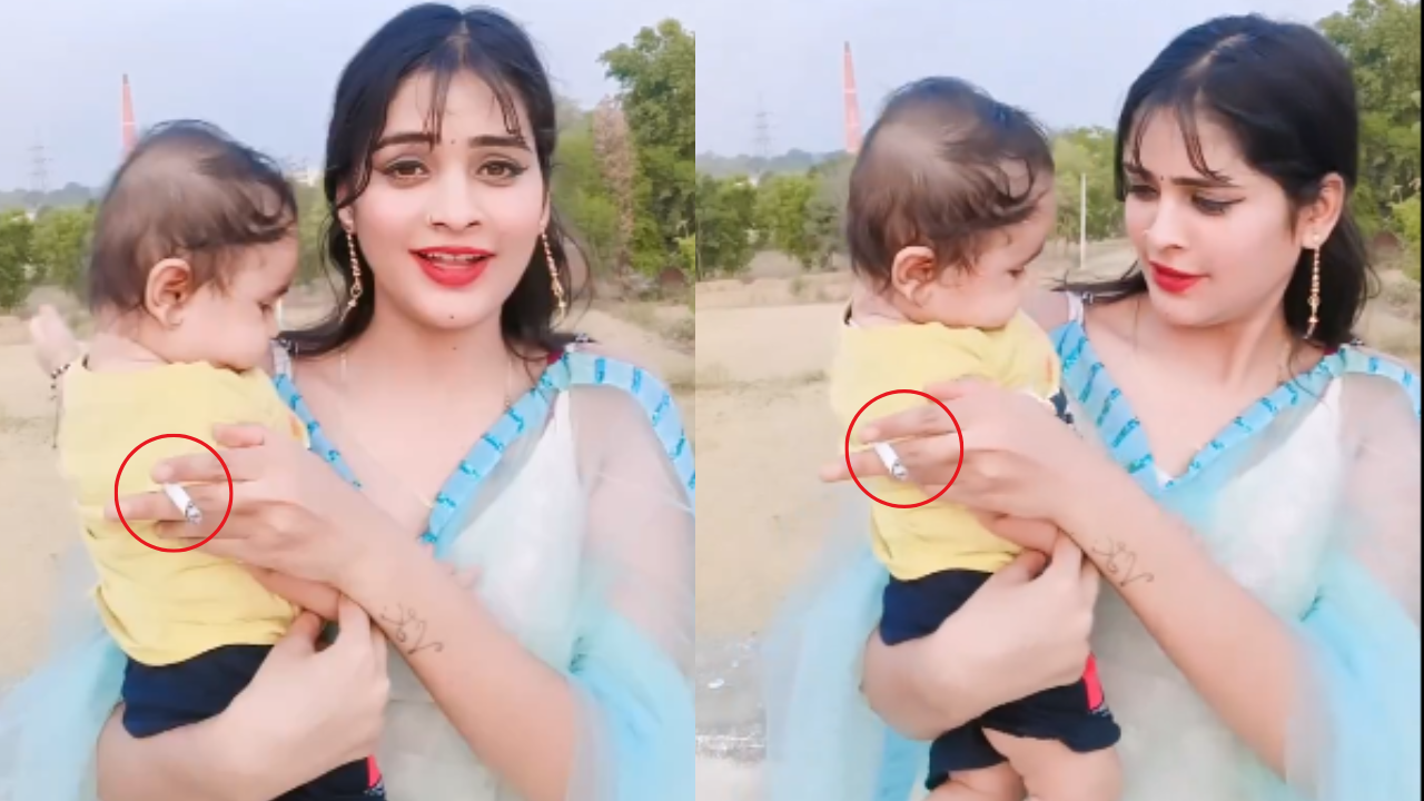 बच्चे को गोद में लेकर सिगरेट पीती महिला।