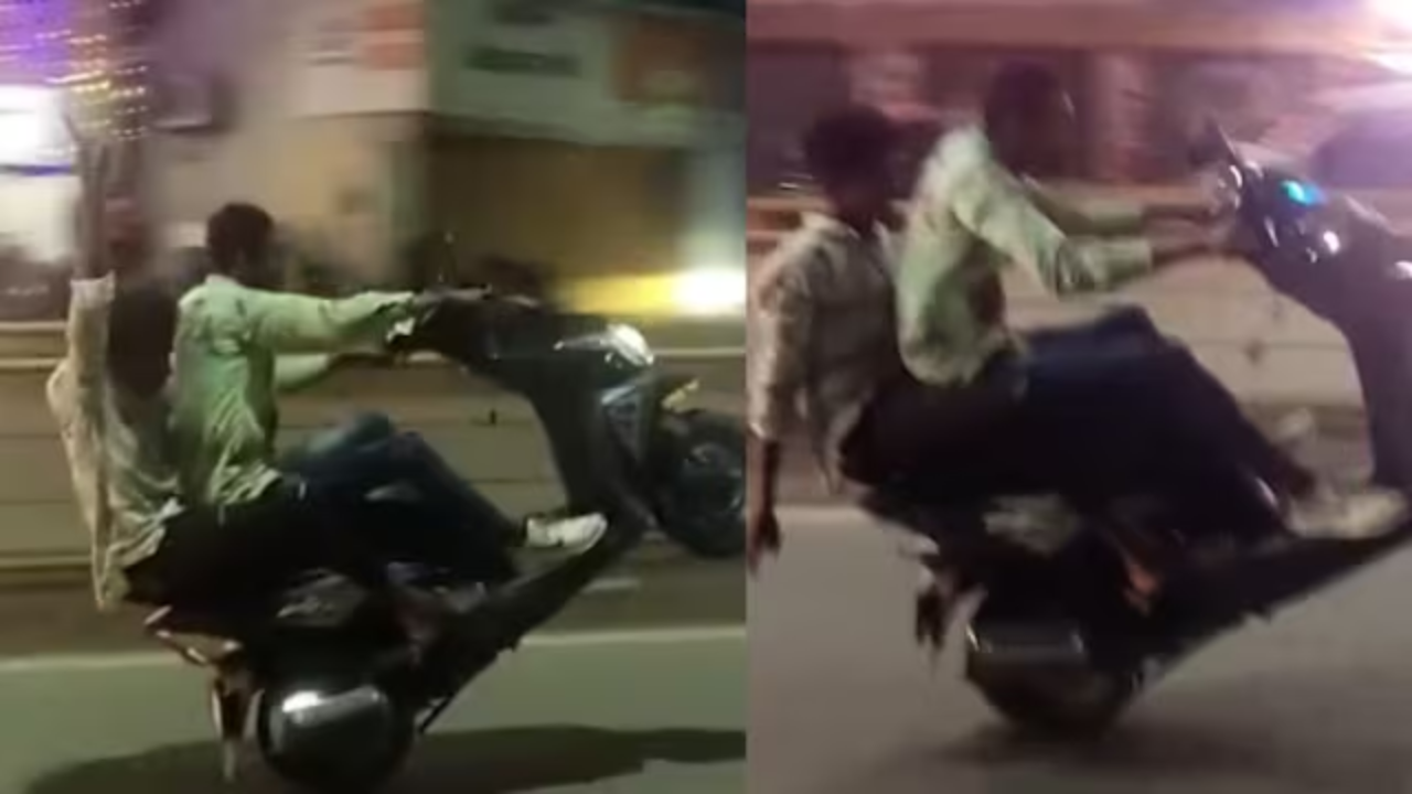 स्कूटी से स्टंट करते लड़के।