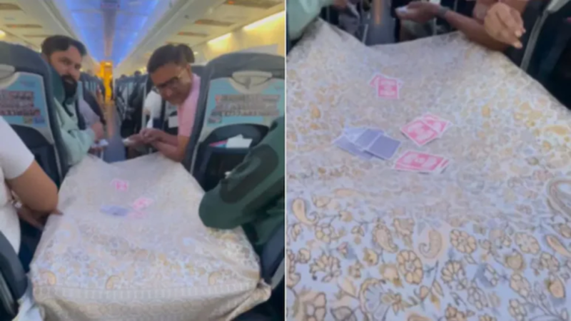 प्‍लेन में ताश खेलते लोग।